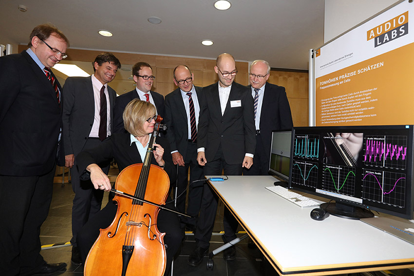 Interesting research topics at the AudioLabs: Sensors enable the exact determination of a tone pitch while a cello is being played. (From left to right): Dr. Bernhard Grill, Deputy Director of Fraunhofer IIS; Prof. Dr. Joachim Hornegger, President of Friedrich-Alexander-Universität Erlangen-Nürnberg (FAU); Dr. Florian Janik, Mayor of Erlangen; Prof. Dr. Albert Heuberger, Speaker AudioLabs and Executive Director of Fraunhofer IIS; Fabian-Robert Stöter, scientific staff member AudioLabs; Prof. Dr. Alexander Kurz, Executive Vice President Human Resources, Legal Affairs and IP Management, Fraunhofer-Gesellschaft; Dr. Sybille Reichert, Chancellor of Friedrich-Alexander-Universität Erlangen-Nürnberg (FAU) © Fraunhofer IIS/Kurt Fuchs